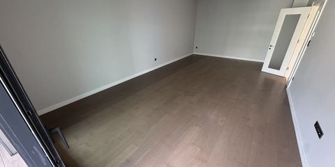 Cardboard boxes on the floor of an empty apartment living room, daylight falling through the window