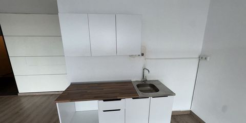 Boş bir dairenin sade mutfak nişi; beyaz dolaplar, ahşap desenli tezgâh ve paslanmaz çelik eviye