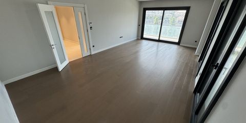 A fitted kitchen in a modern Istanbul apartment, worktop and induction hob beside a balcony door with the city beyond
